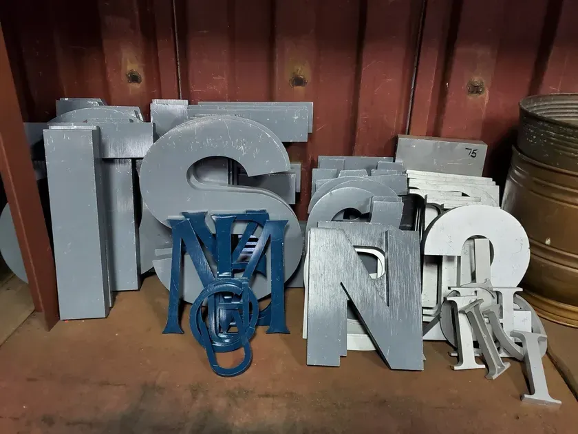 A bunch of metal letters are stacked on top of each other.