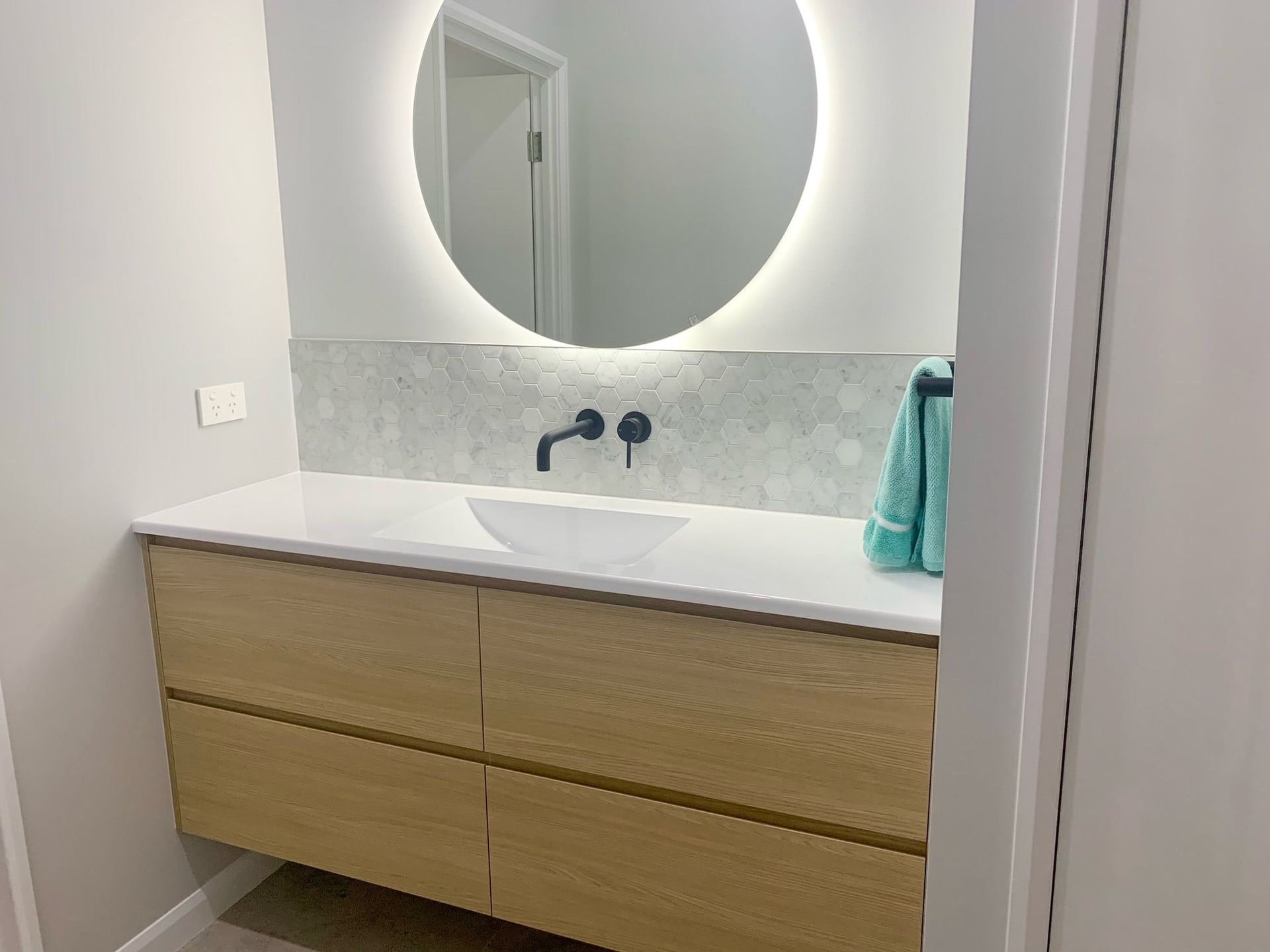 A Bathroom With a Sink and a Round Mirror — Olive & White Cabinetmaking in Park Avenue, QLD