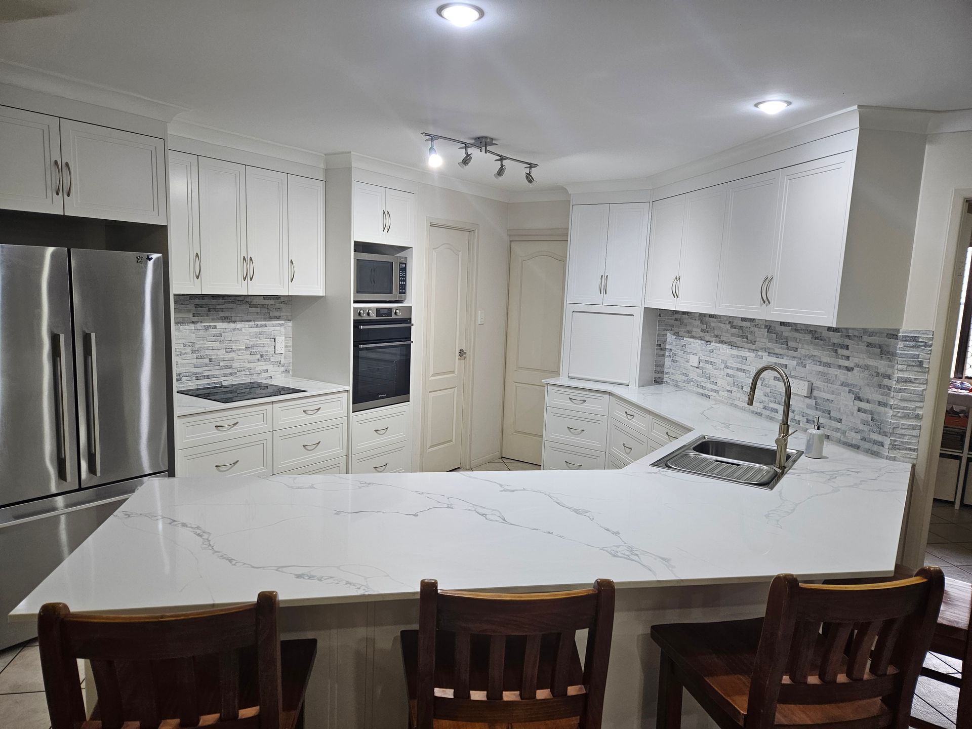A Kitchen With a Dark Counter Top and a Black Refrigerator — Olive & White Cabinetmaking in Park Avenue, QLD