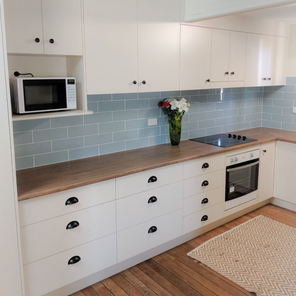 A Kitchen With White Cabinets and a Vase of Flowers on the Counter — Olive & White Cabinetmaking in Park Avenue, QLD