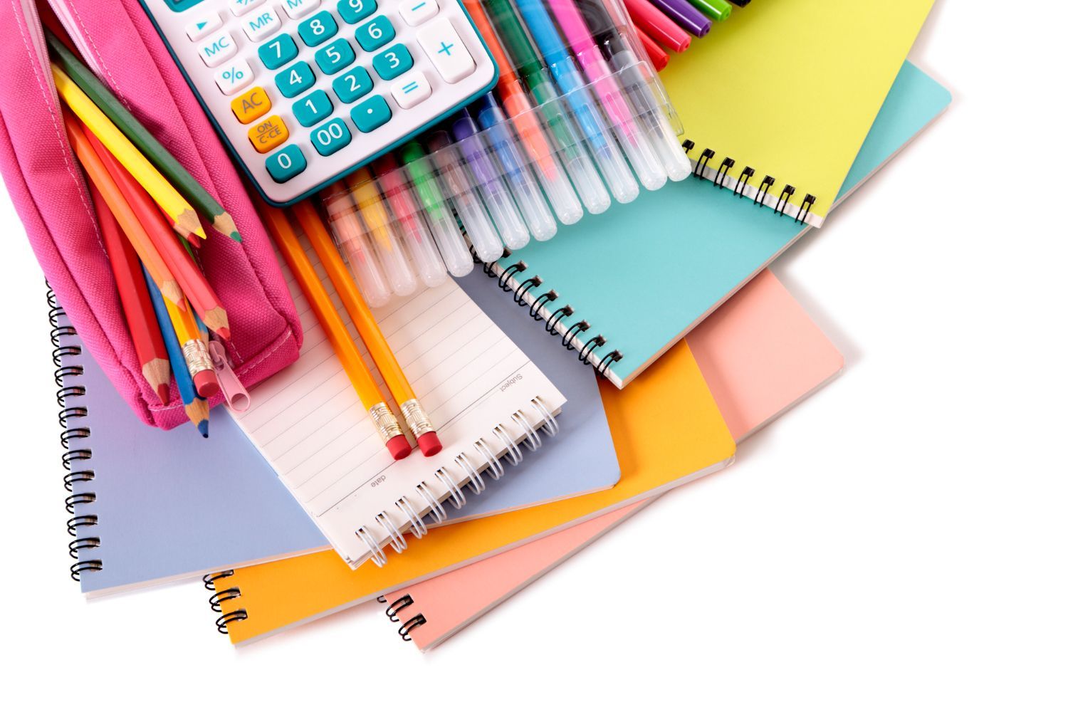 Vista desde arriba de varios útiles escolares, incluyendo cuadernos, una calculadora, bolígrafos de colores y lápices en un estuche rosa.