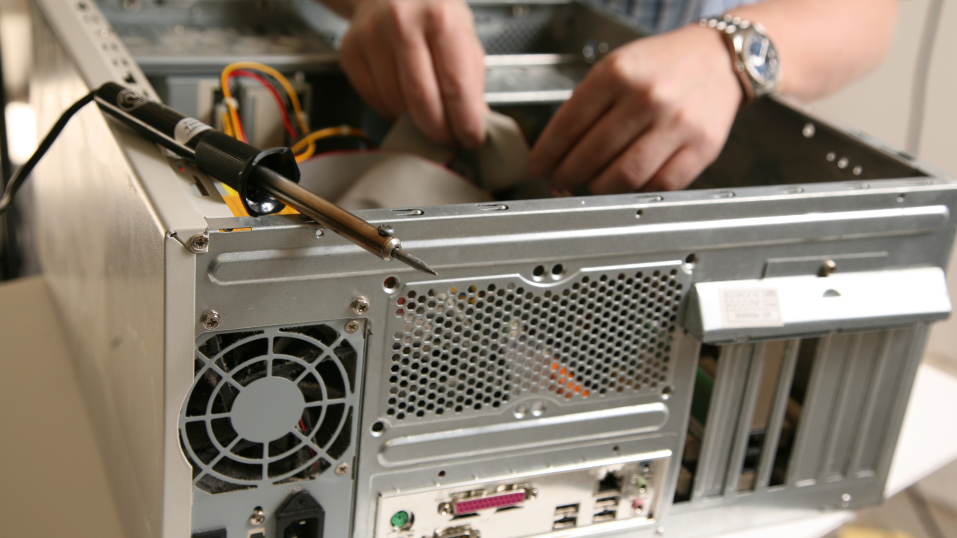 technician repair desktop pc and working on pc cabling with soldering iron on pc case