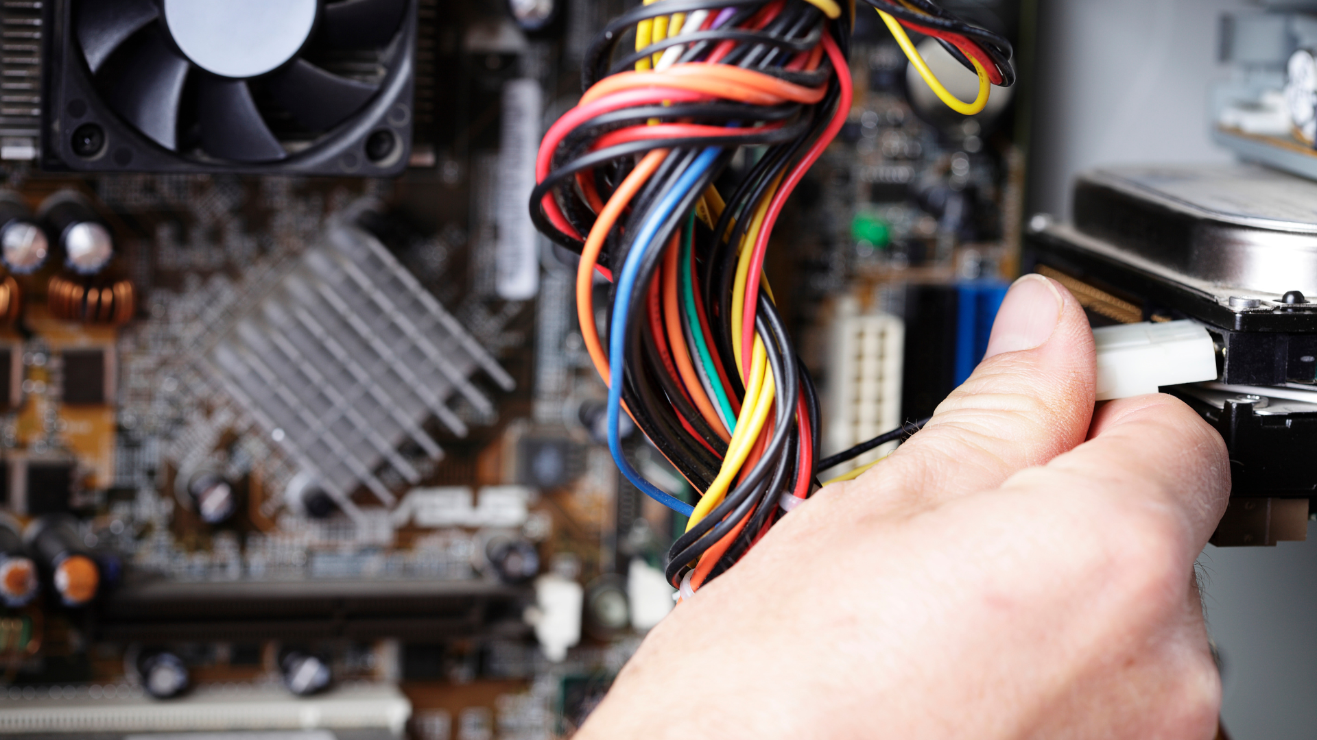 technician connecting components & performing cable management on desktop pc