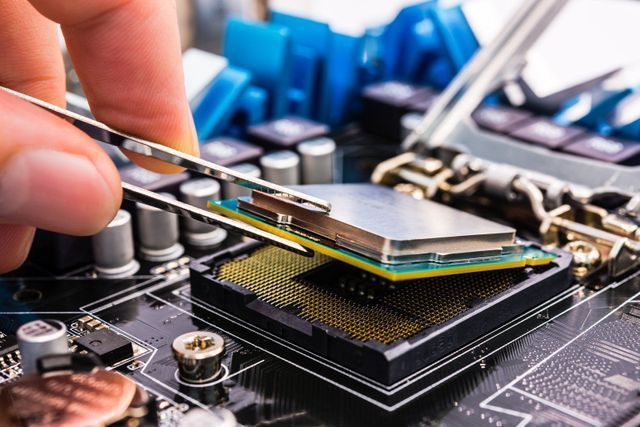 technician placing cpu in cpu bracket during pc repair using esd safe tweezers