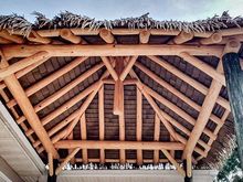 Wooden pergola with a thatched roof.