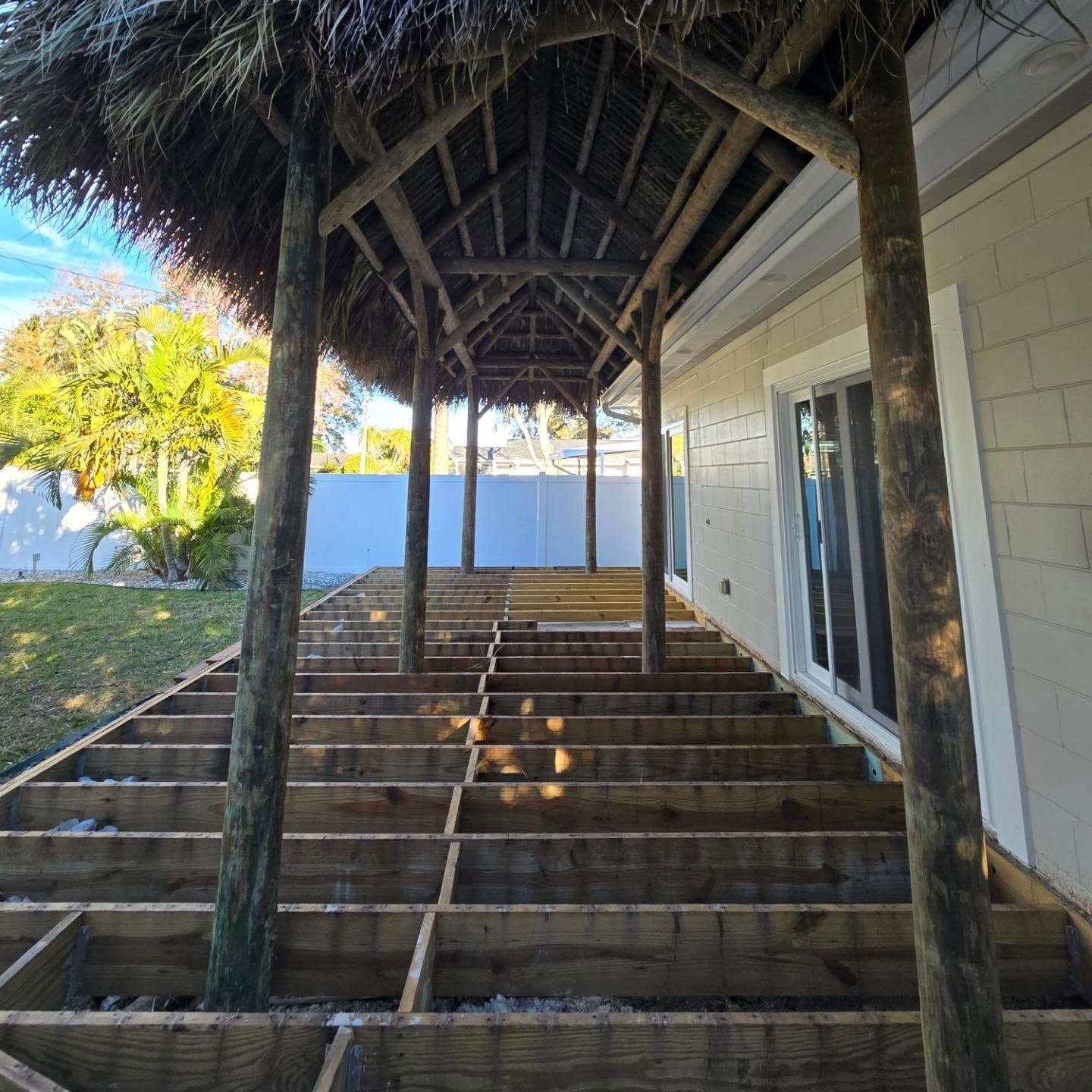 Wooden deck under construction, covered by a thatched roof. Wooden deck under construction, covered by a thatched roof.