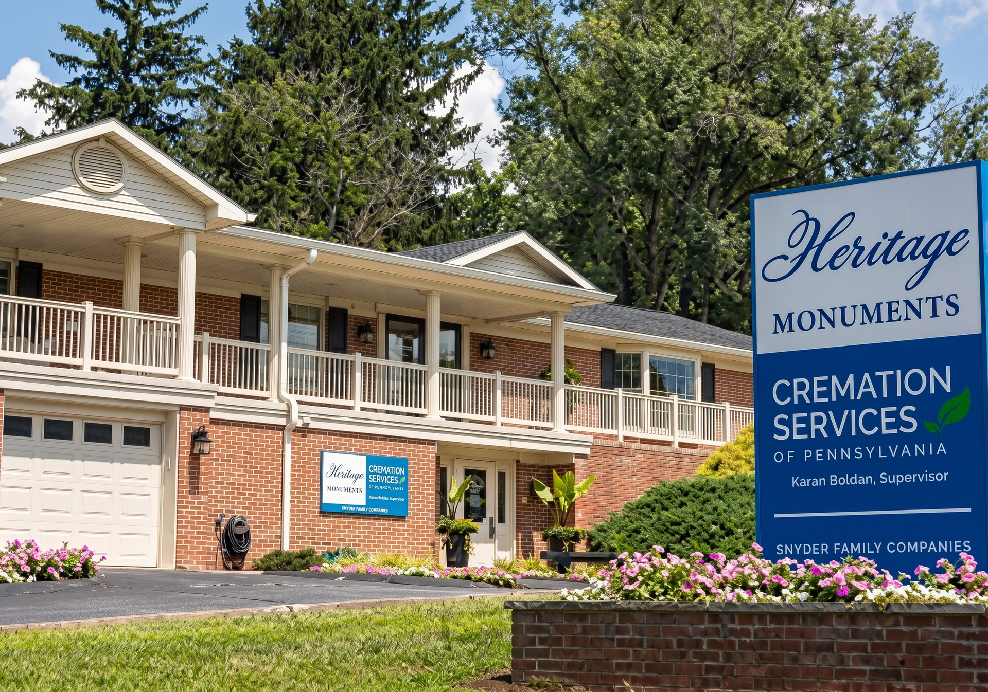 Heritage Monuments funeral home with sign, brick building, and flower bed