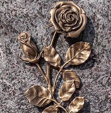 Bronze rose and leaves wall relief on a speckled stone background