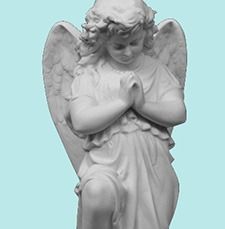 White praying angel statue with folded hands and wings against a light blue background