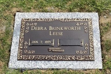 Gravestone plaque on grass for Debra Brinkworth Leese, with birth and death dates.