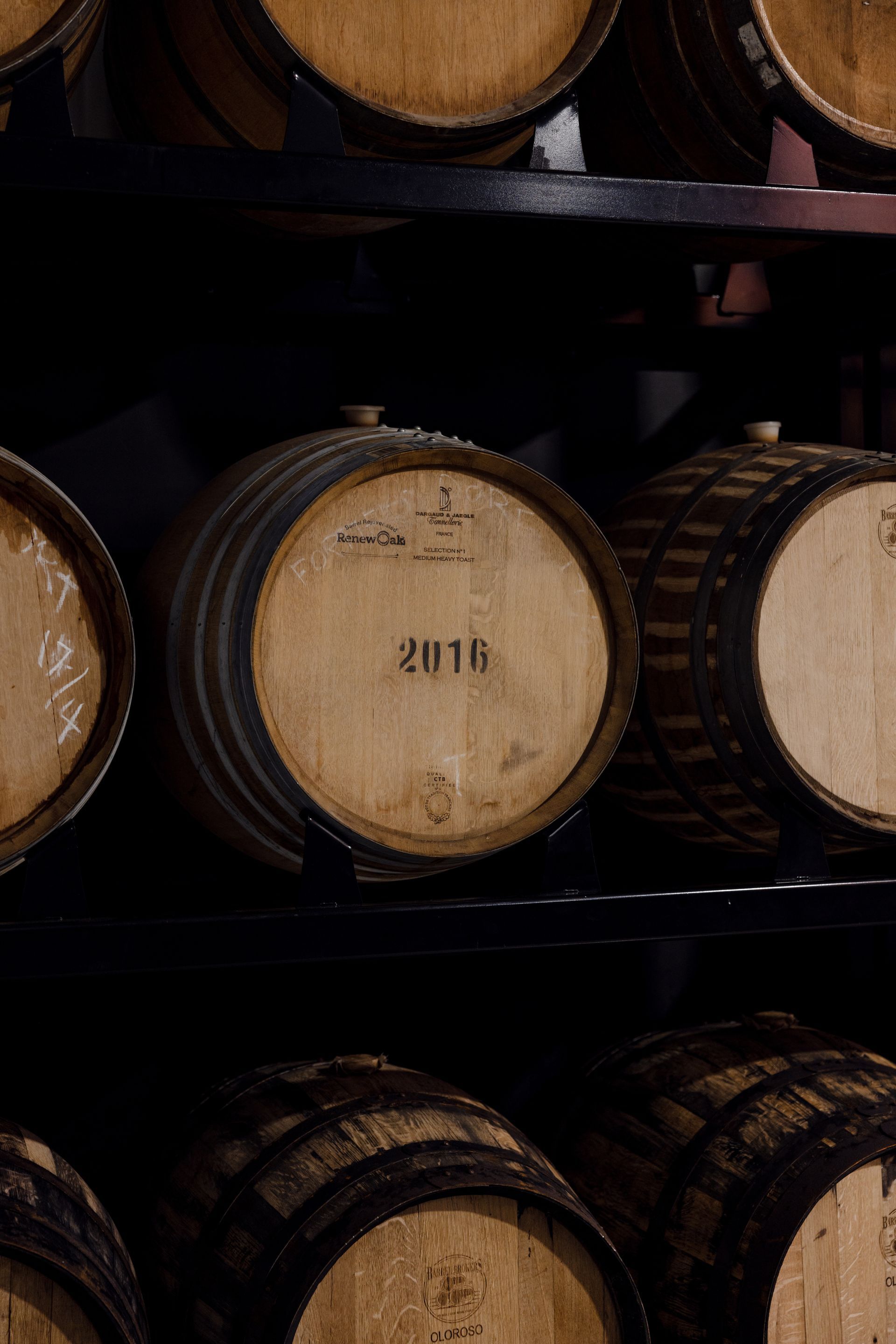 Oak whisky barrels resting inside The Outback Distilling Co.'s barrel hall in Outback Queensland.