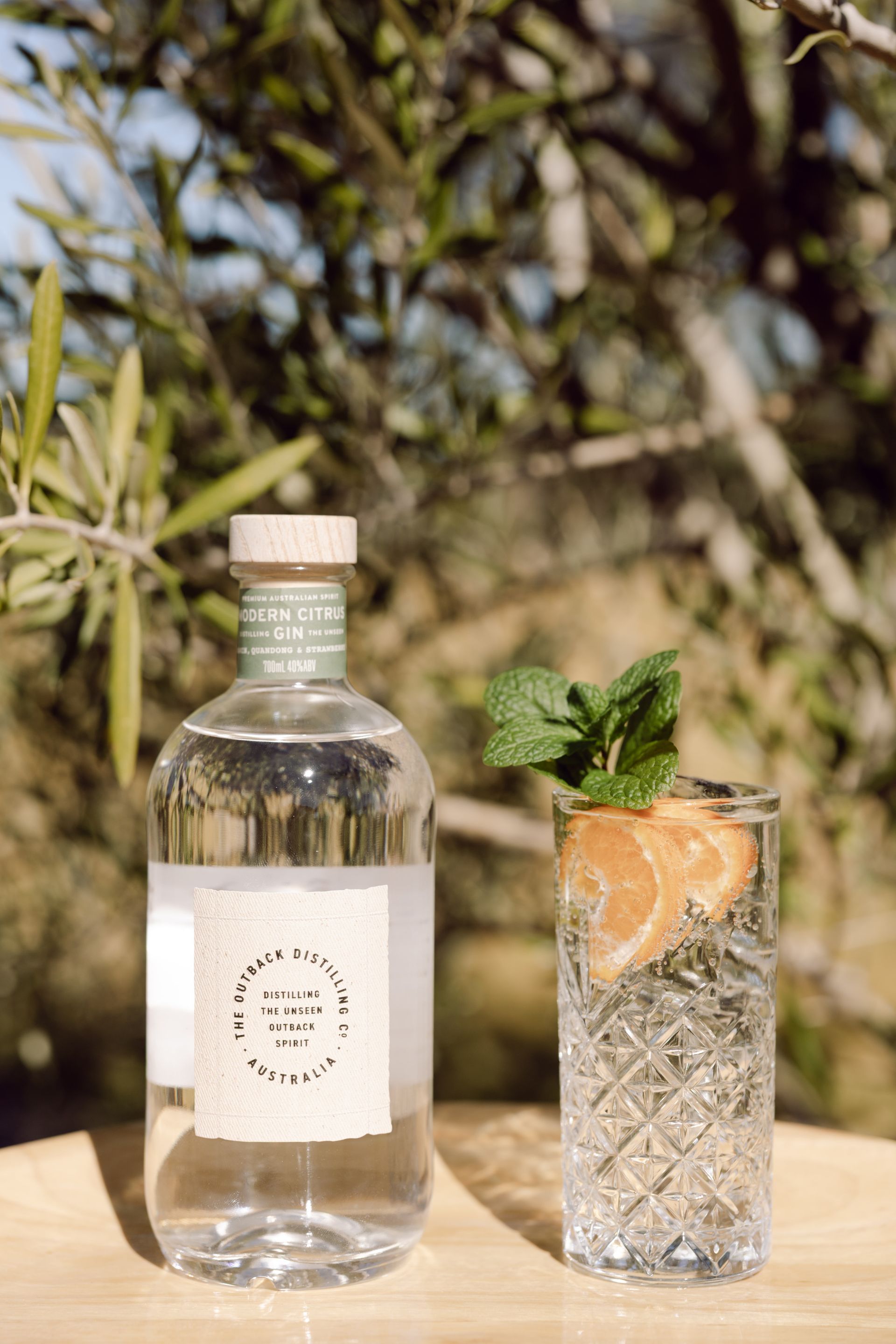 Australian Native Dry Gin by The Outback Distilling Co on barrel in distillery setting.