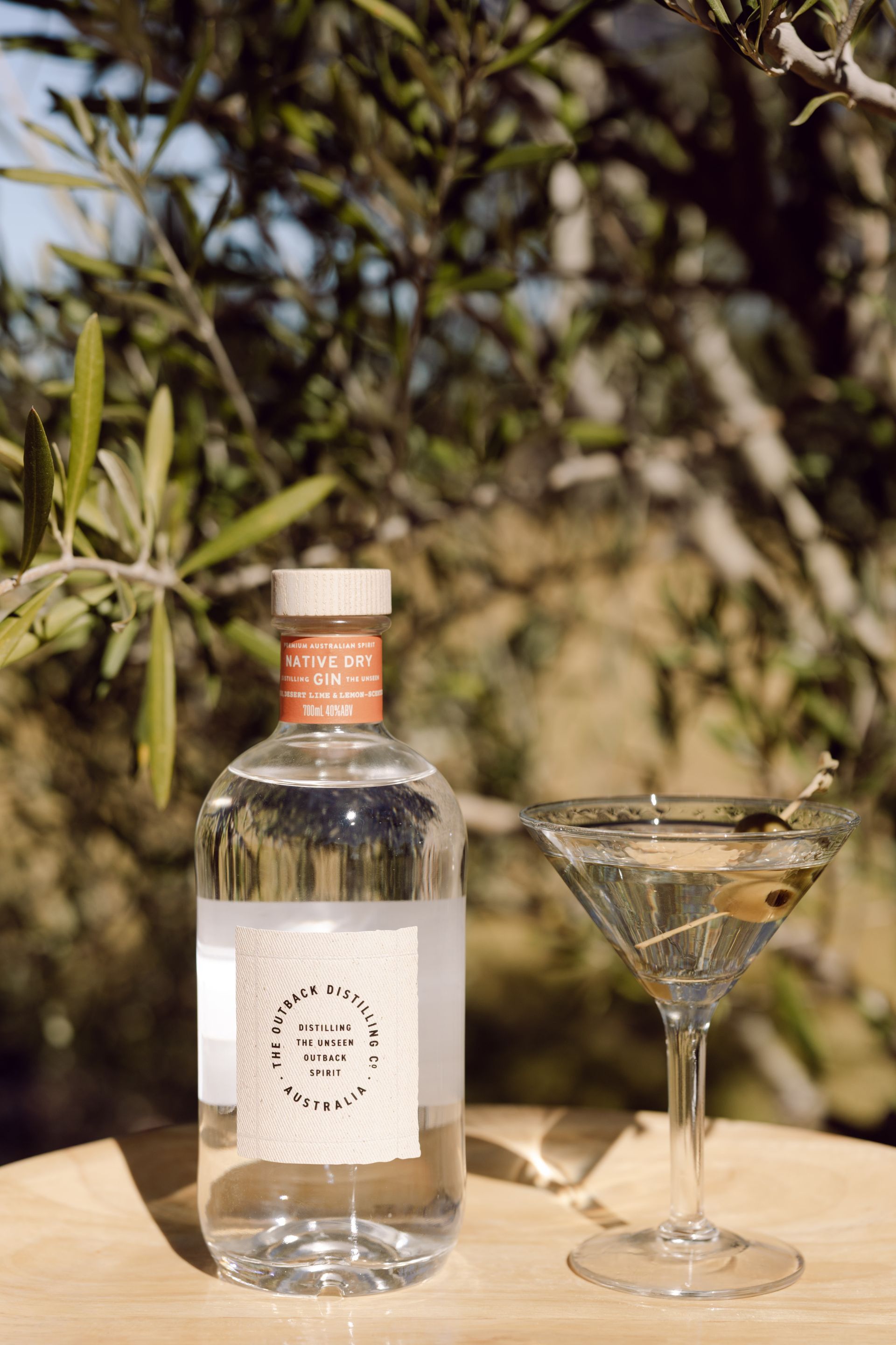 Australian Native Dry Gin by The Outback Distilling Co on barrel in distillery setting.