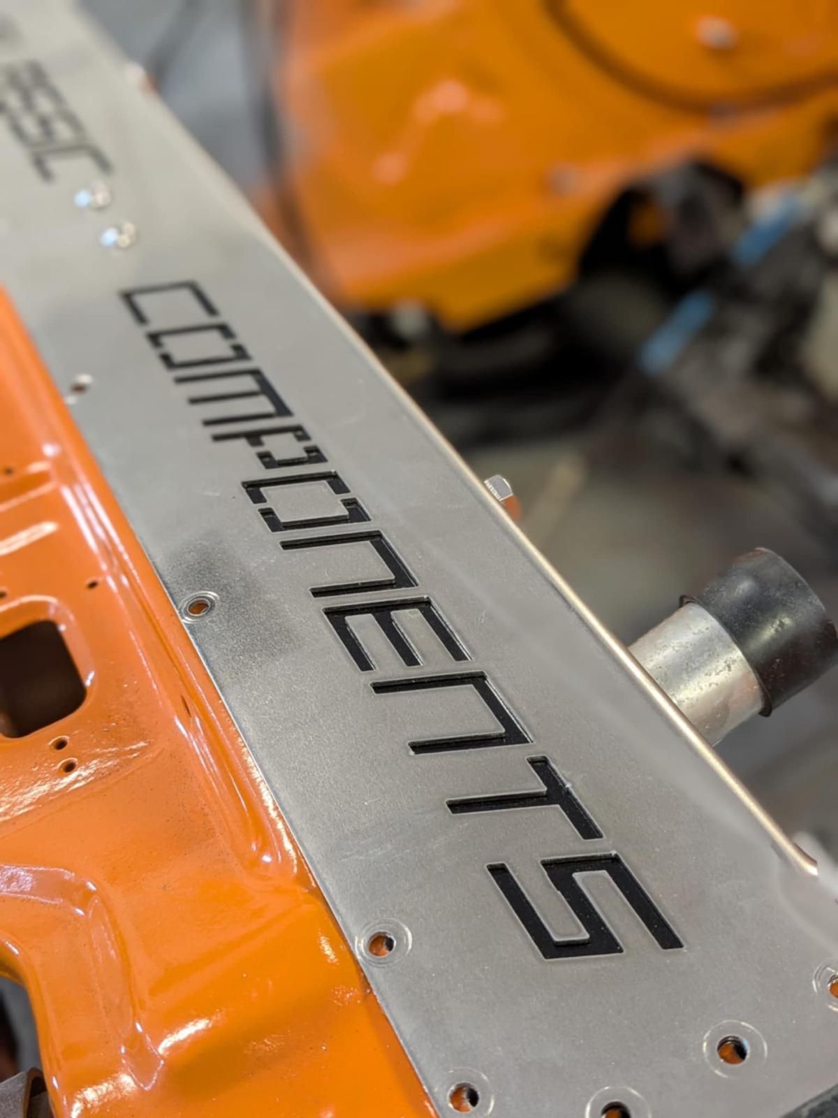 Close-up of an orange machine component with a silver panel labeled “COMPONENTS”