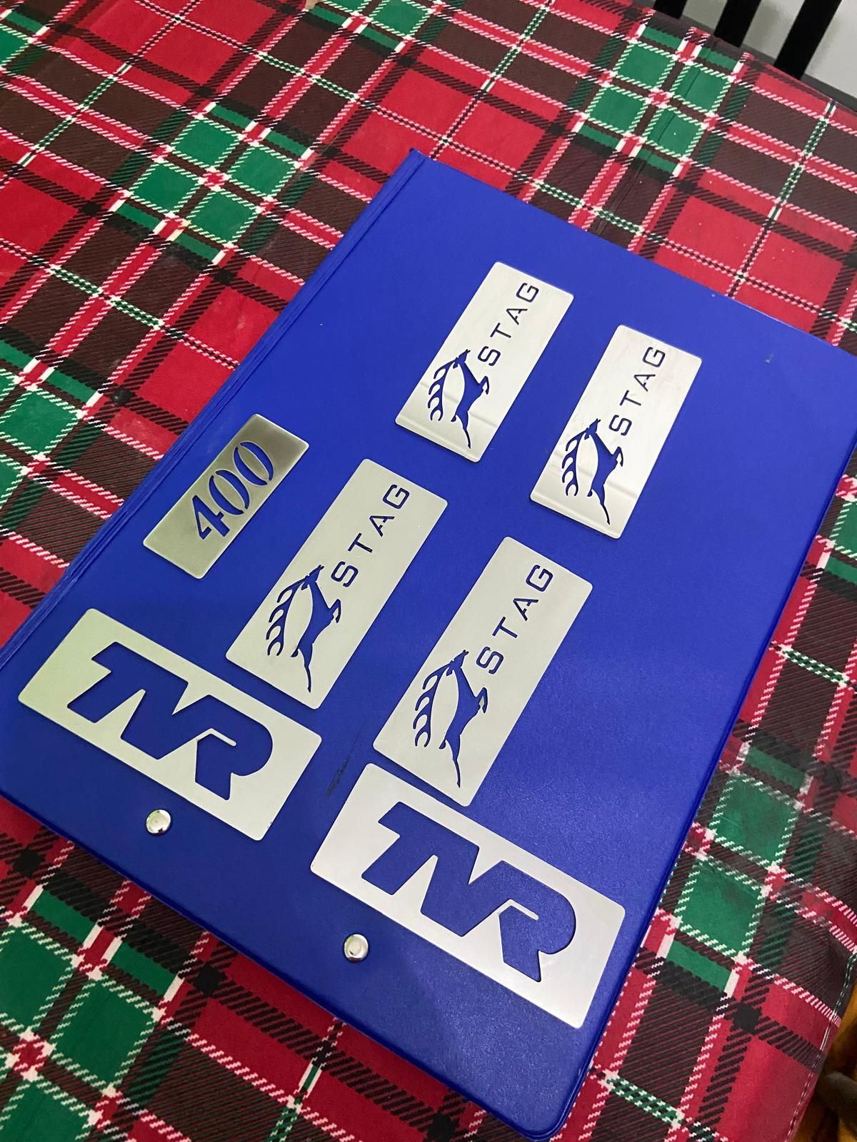 Blue board with several small logo stickers and a “400” label on a red plaid blanket