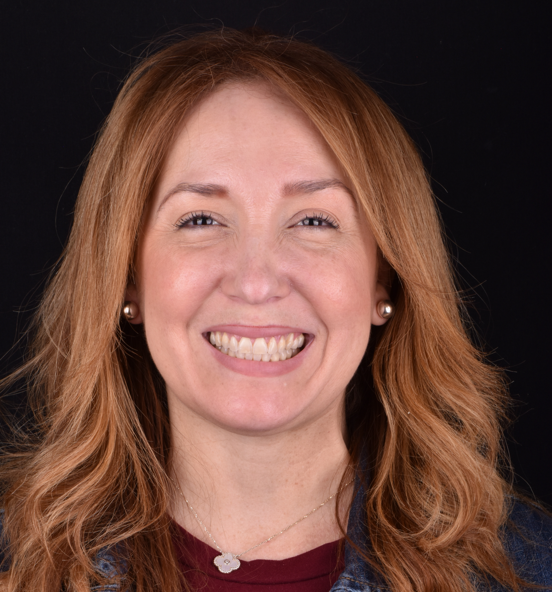 Smiling woman with red hair against a black background