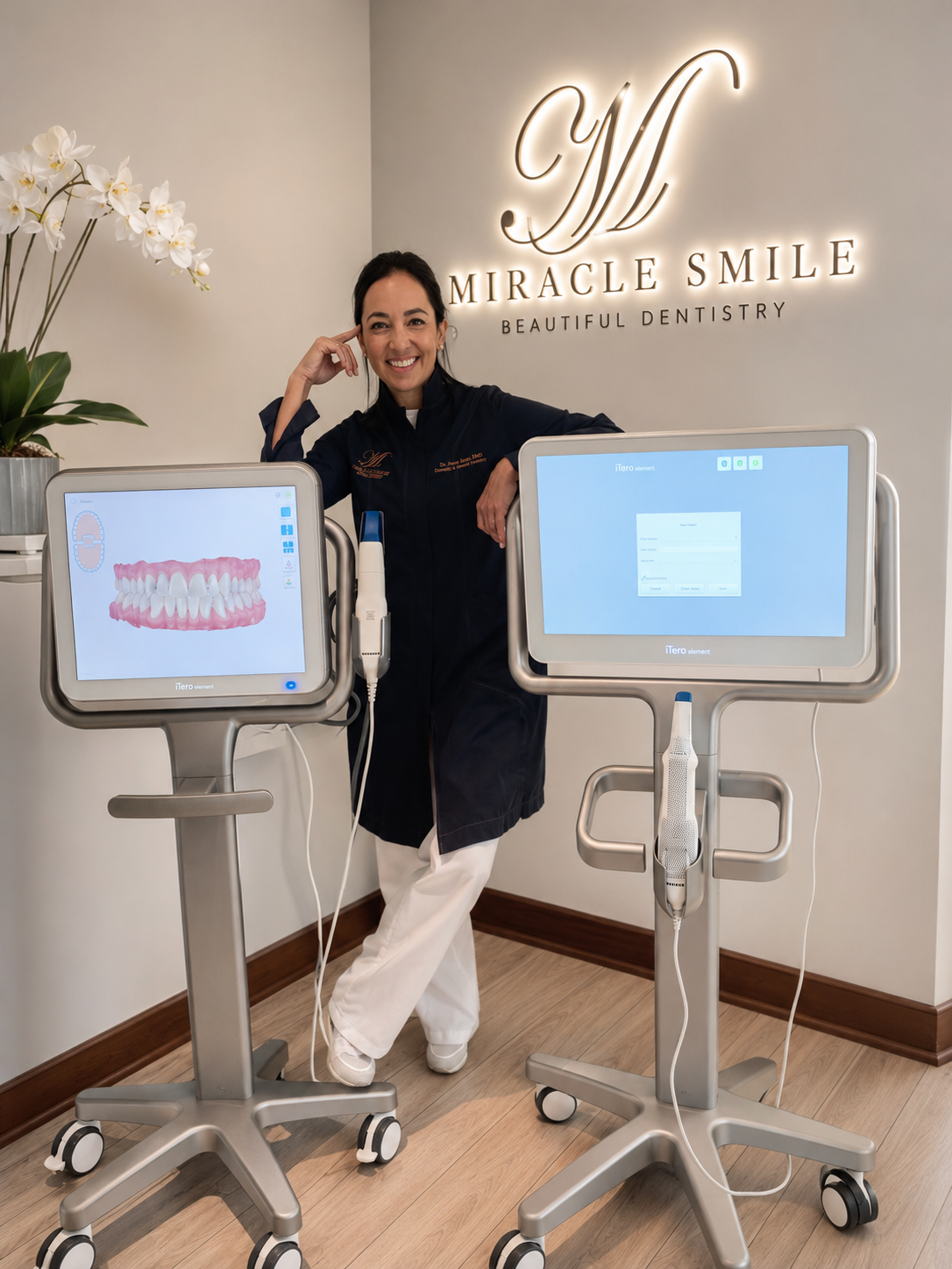 Person posing beside two dental display machines in a clinic, smiling with arms crossed.