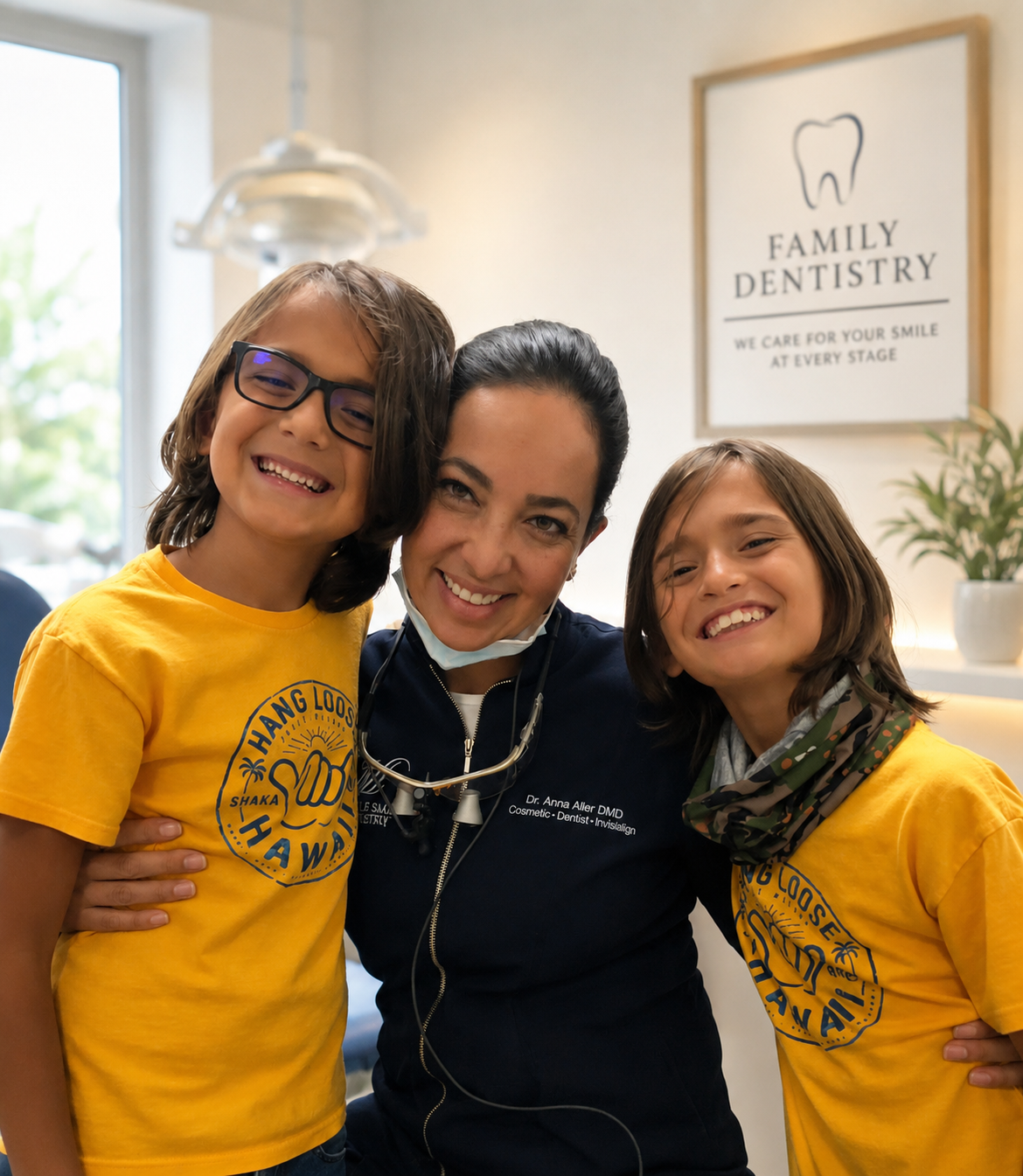 Two children hugging a smiling dentist in a bright family dentistry office
