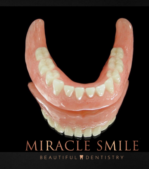 Pink dental dentures with “MIRACLE SMILE” text on a black background