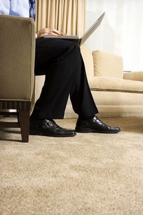 man sitting on sofa using laptop