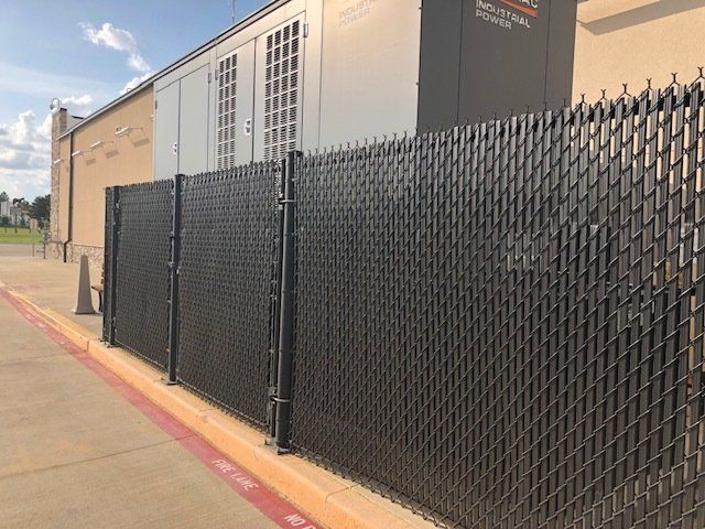 A chain link fence is sitting next to a building.