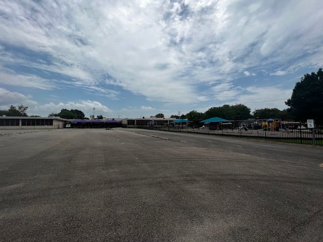 An empty parking lot with a building in the background