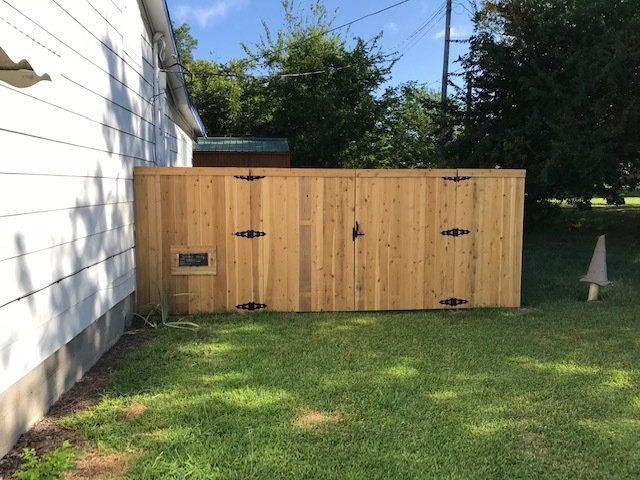 A wooden fence is in the backyard of a house.