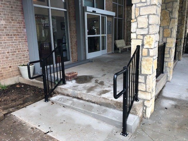 A brick building with stairs and a black railing