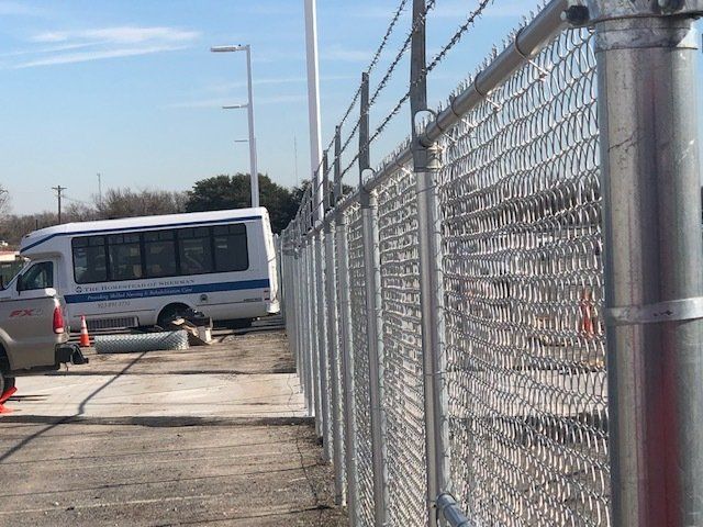 A bus is parked behind a chain link fence