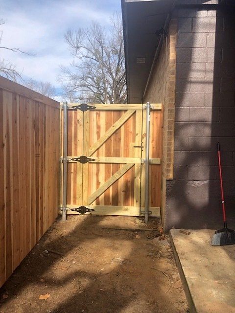 A wooden fence with a gate in the backyard of a house.