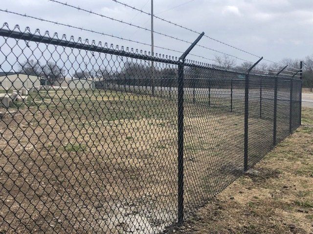 A chain link fence with barbed wire on top of it