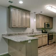 Modern kitchen with light wood cabinets, granite counters, and stainless steel appliances