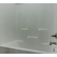 White bathtub and shower with frosted glass wall and chrome fixtures in a bathroom