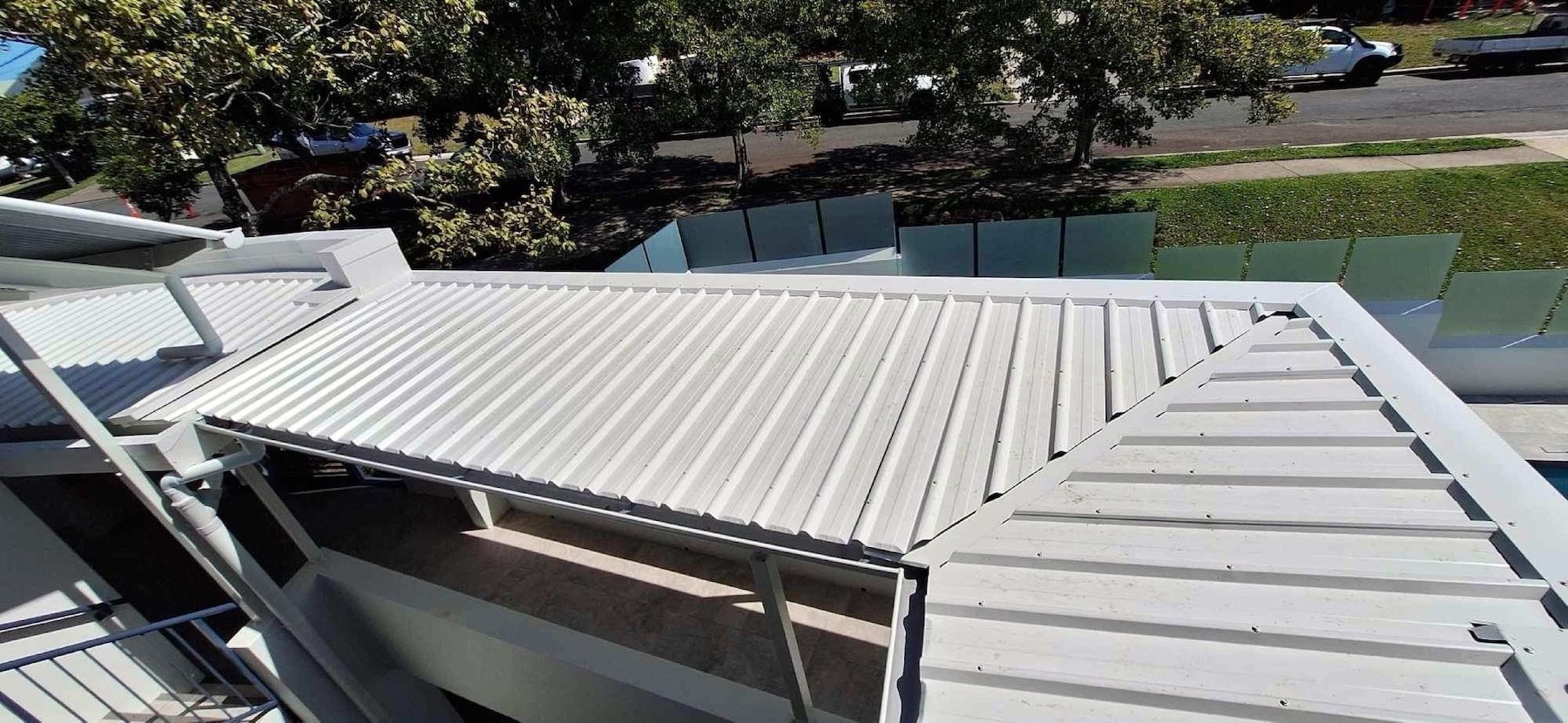 A Man Is Working On The Roof Of A House — Coastal Roof & Gutter Services In Coolum Beach, QLD