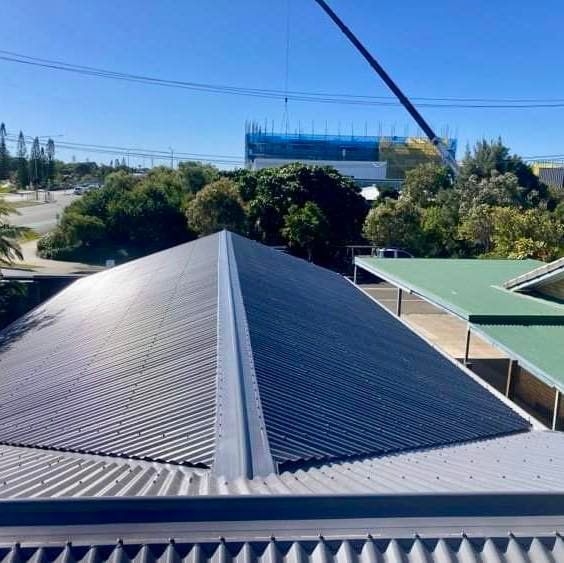 A View Of A Roof With A Crane In The Background.— Coastal Roof & Gutter Services In Coolum Beach, QLD