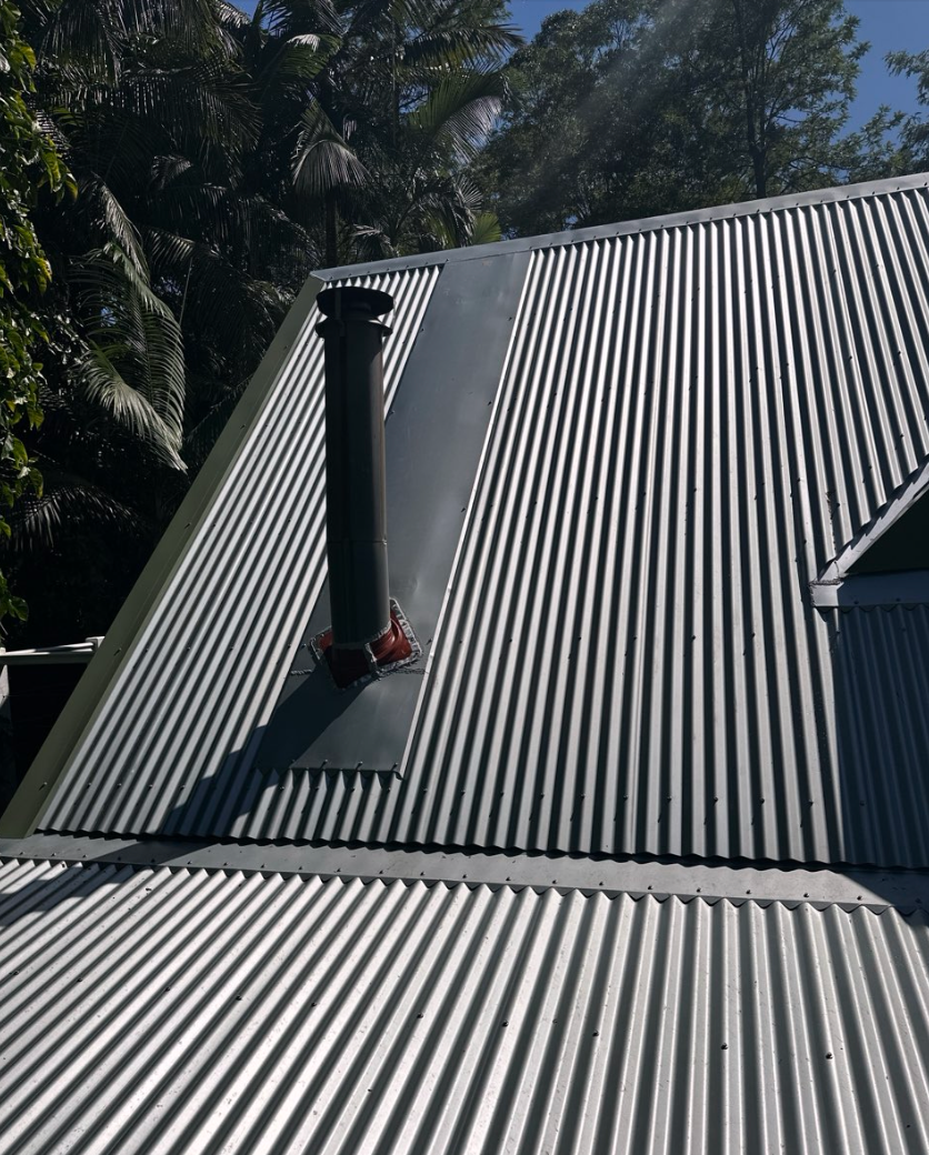 Two Construction Workers Are Working On A Roof — Coastal Roof & Gutter Services In Coolum Beach, QLD
