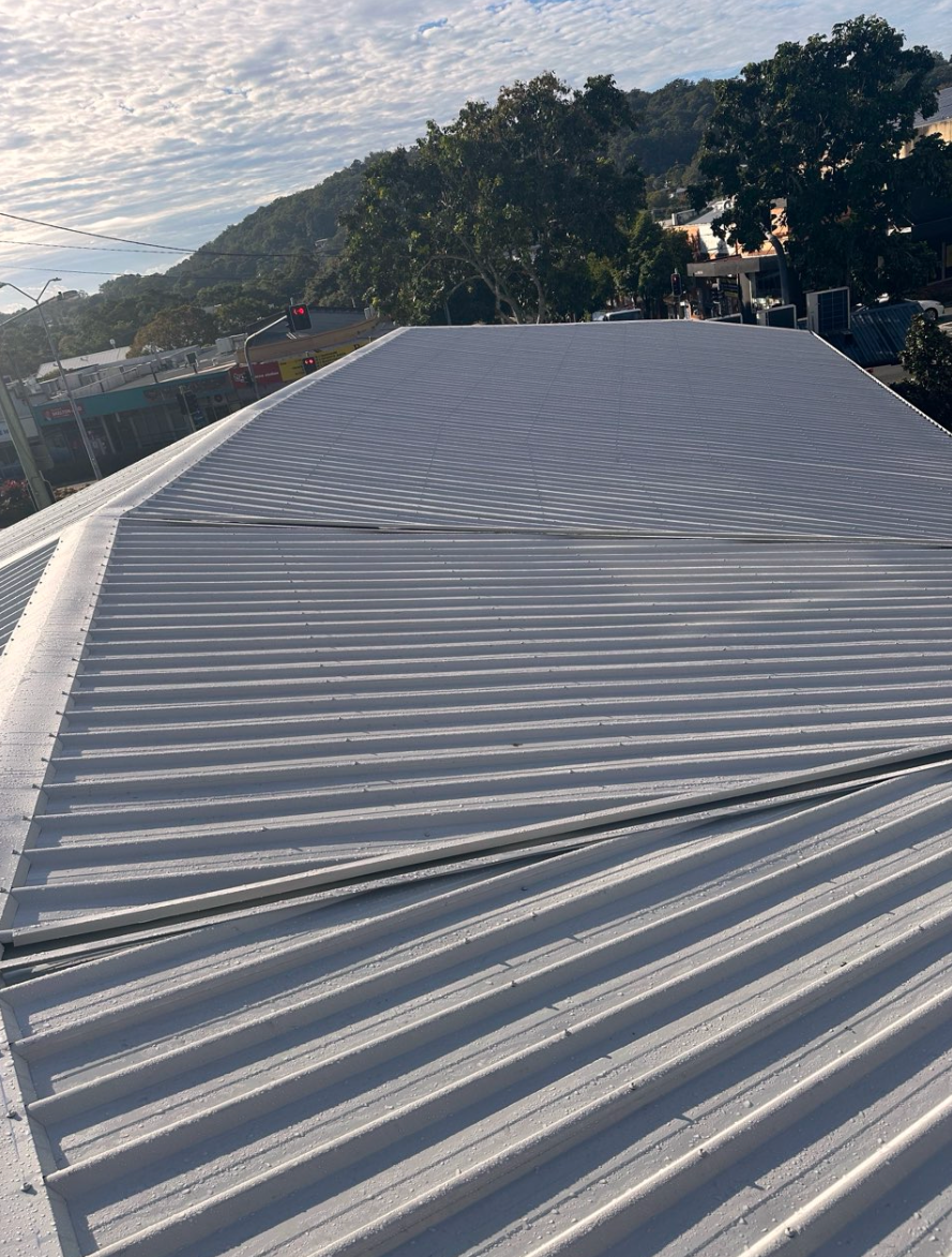 A Brick Building With A Red Roof And A Chimney — Coastal Roof & Gutter Services In Coolum Beach, QLD