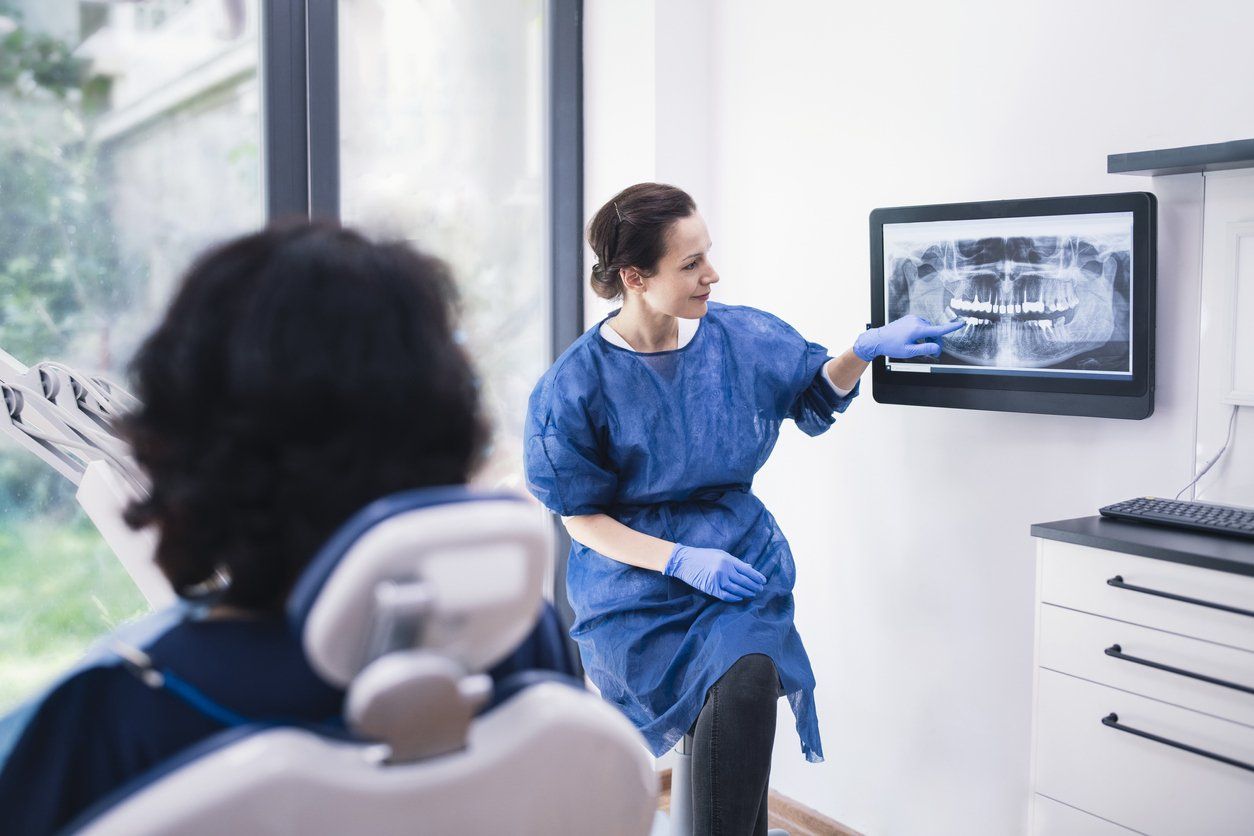 A dentist is showing a patient an x-ray of their teeth.