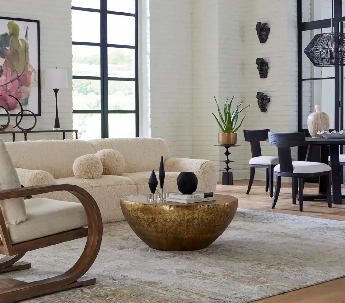 Modern lounge with blue curved sofas, round tables, and patterned wallpaper.