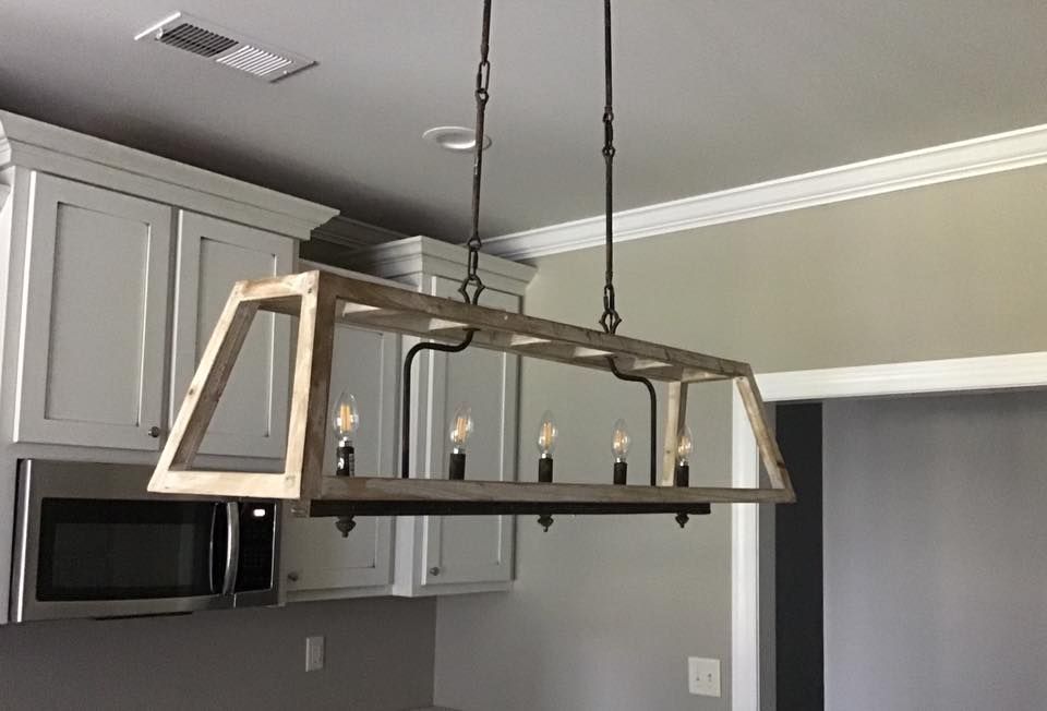 Hanging rectangular chandelier with candle-style bulbs in a gray kitchen