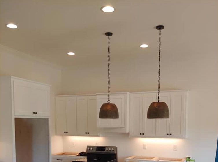 Modern white kitchen with two pendant lights above the counter and stove