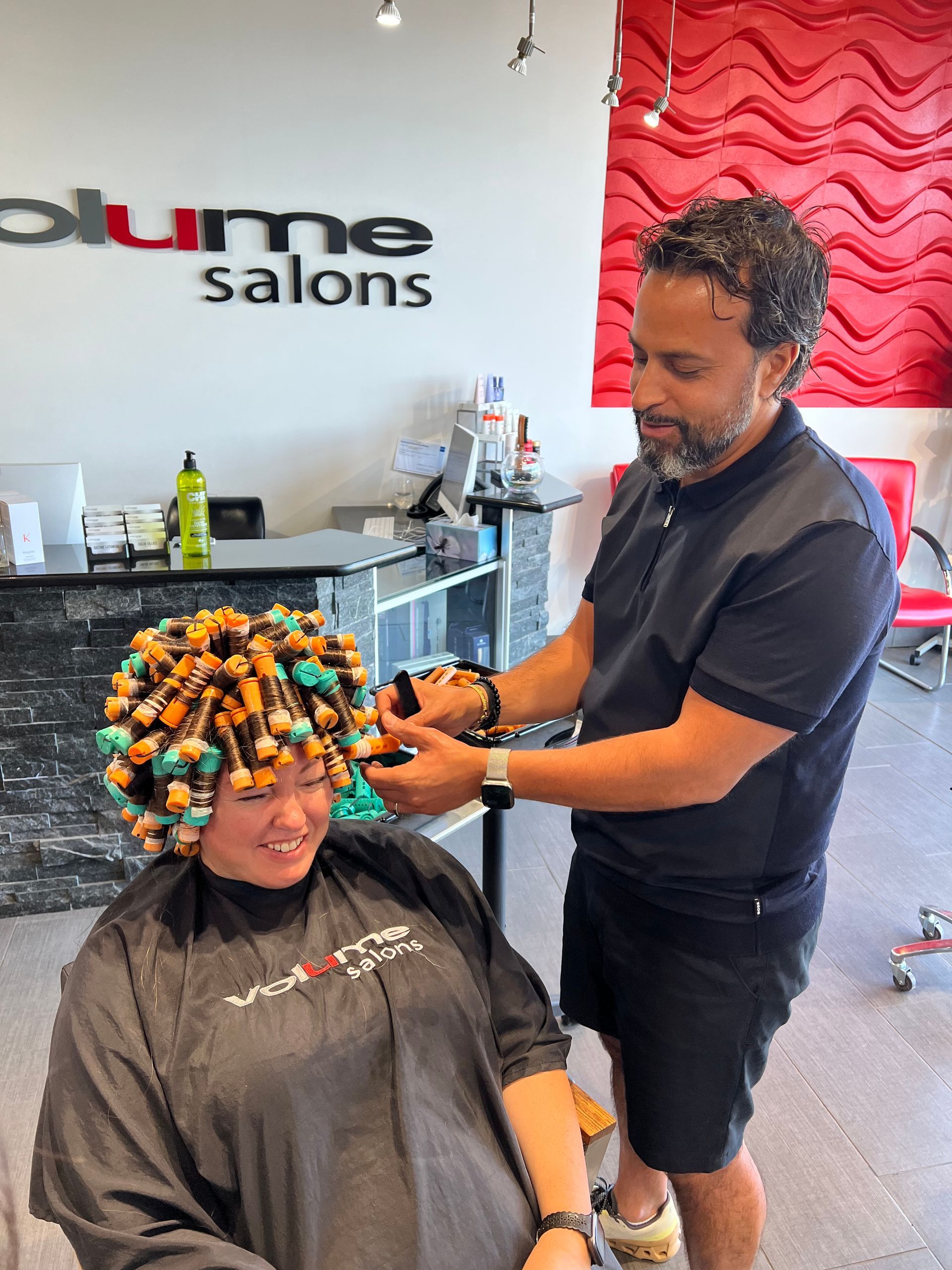 A man is working on a woman 's hair in a salon called plume salons