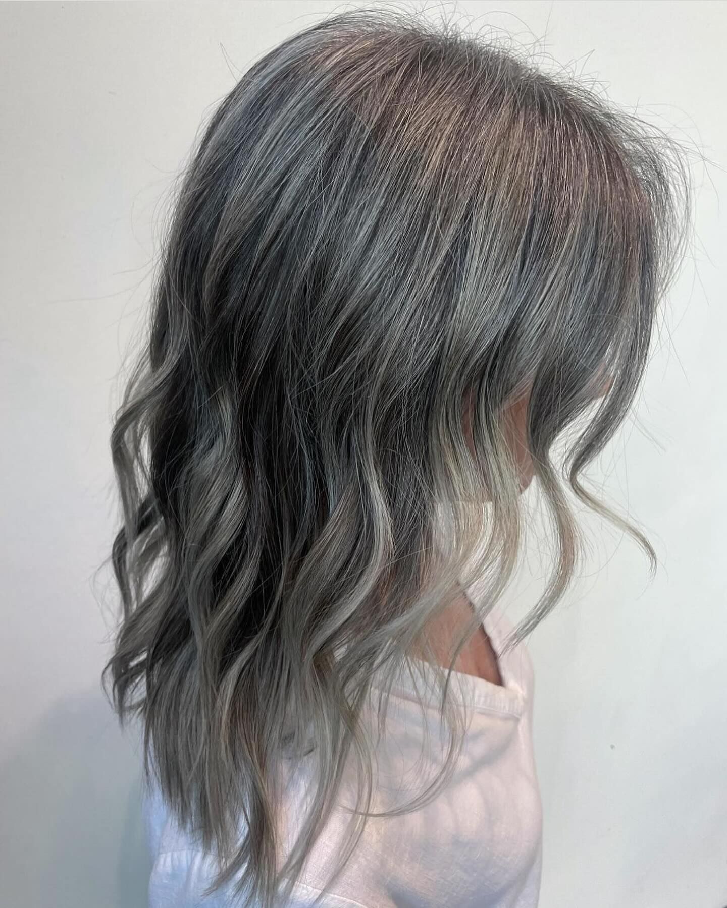 Woman with wavy, gray and blonde hair.