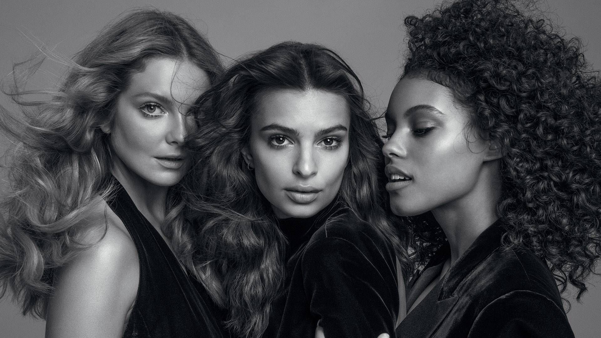 Three women are posing for a black and white photo.