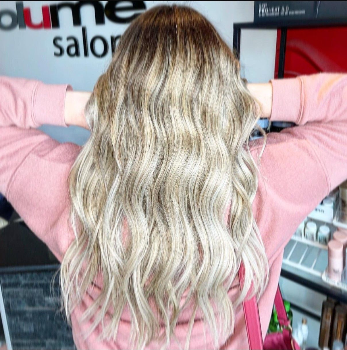 a woman is standing in front of a salon