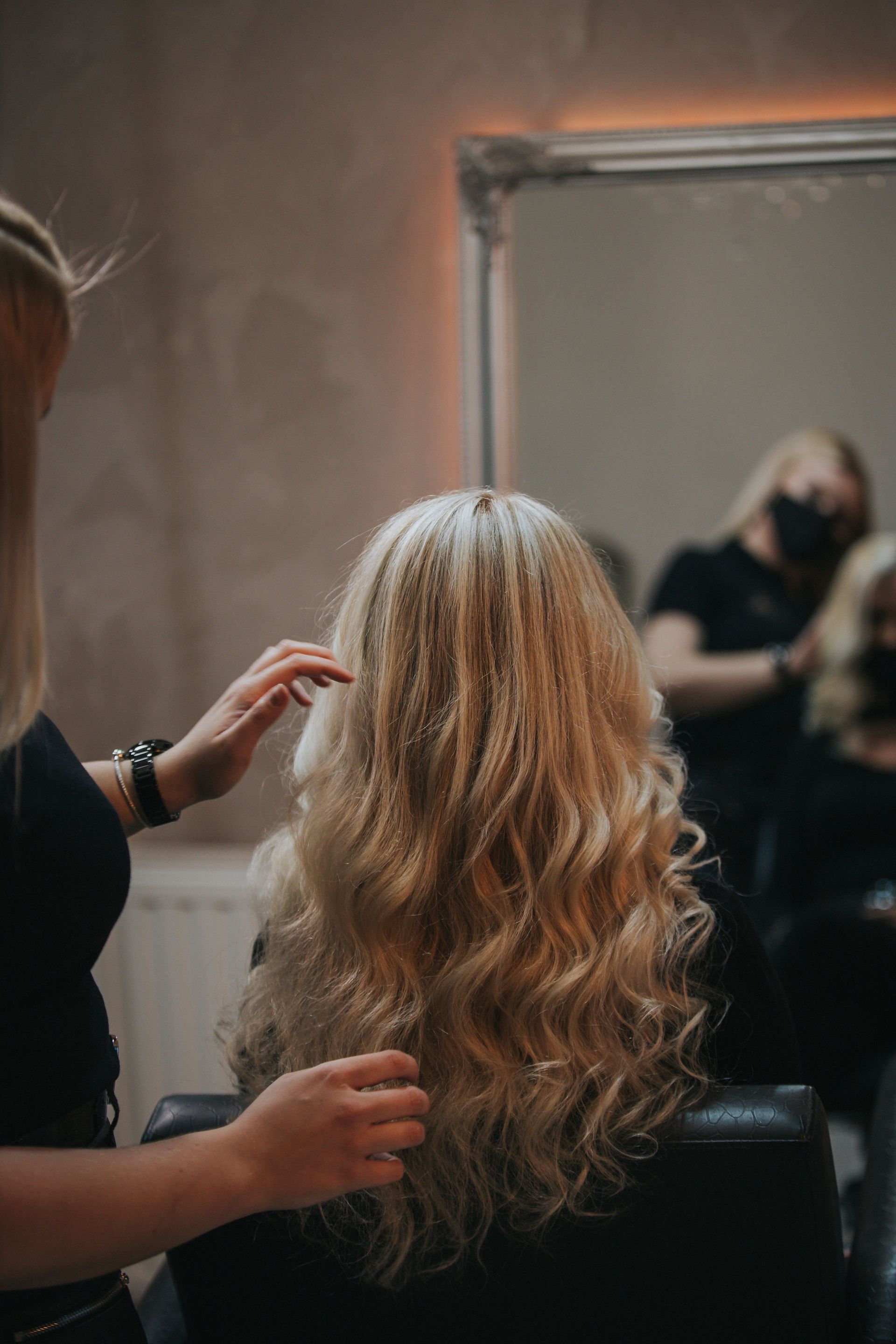 a woman is getting her hair done by a hairdresser in a salon .