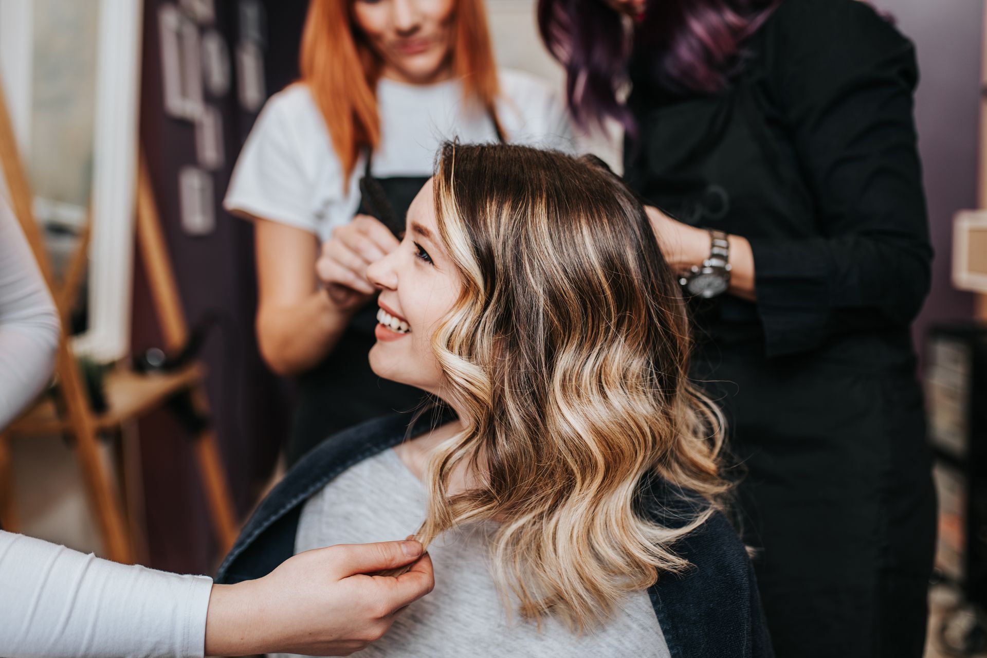 a woman is getting her hair cut by a hairdresser in a salon .
