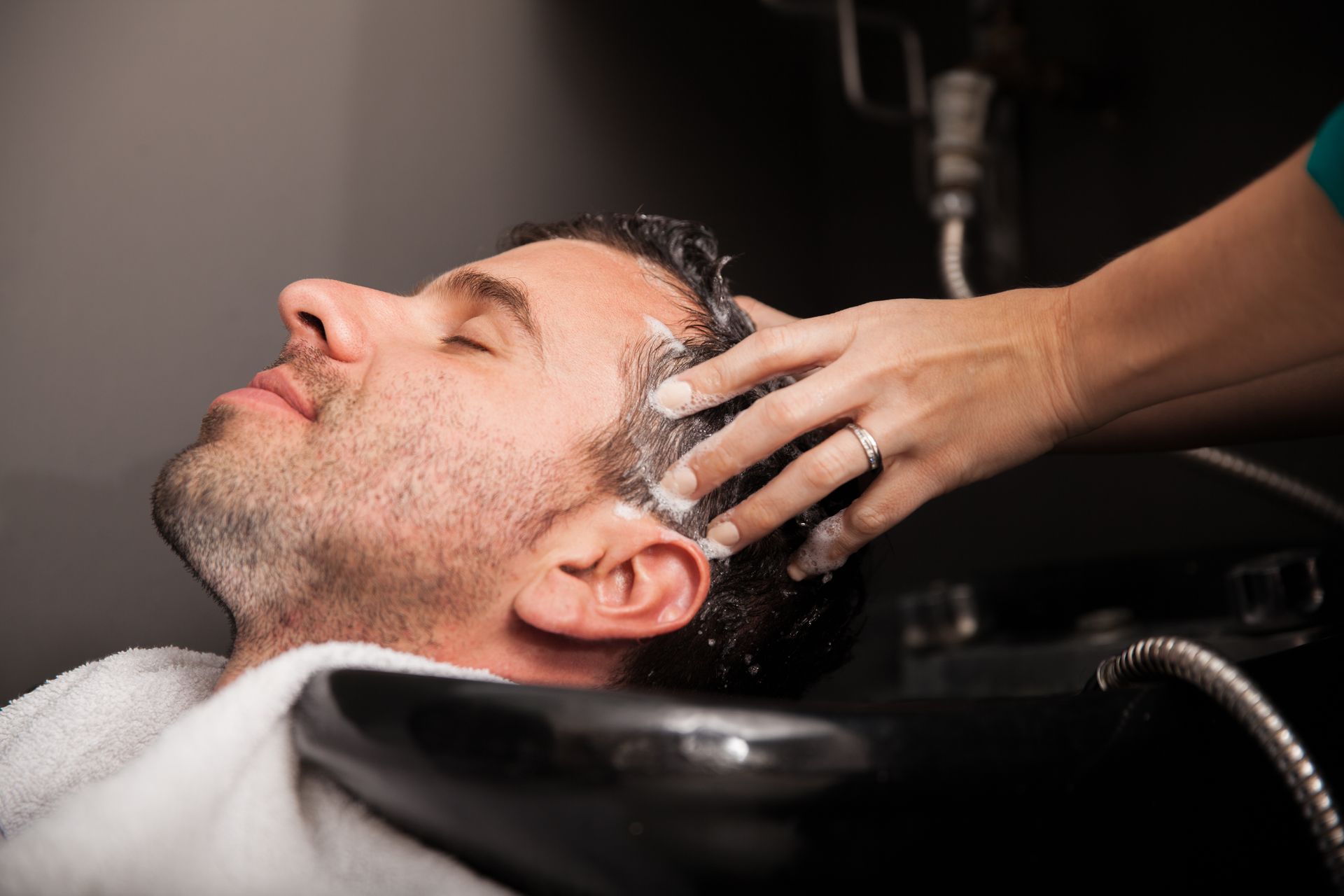 a woman is getting her hair washed in a sink at a salon .