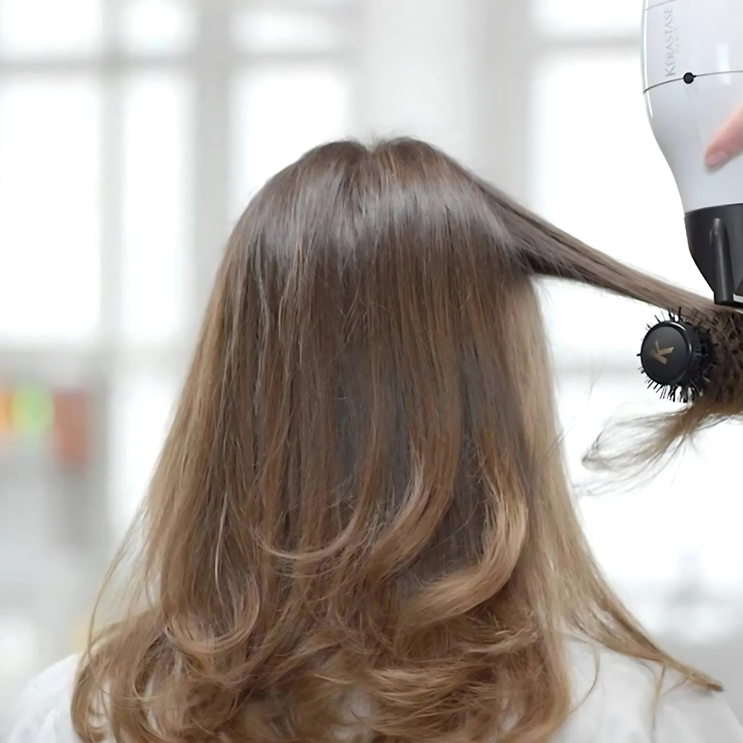 A woman is getting her hair cut by a hairdresser