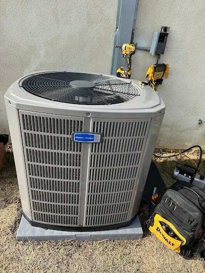 Tip of the Spear HVAC | a large air conditioner is sitting on the ground next to a wall.